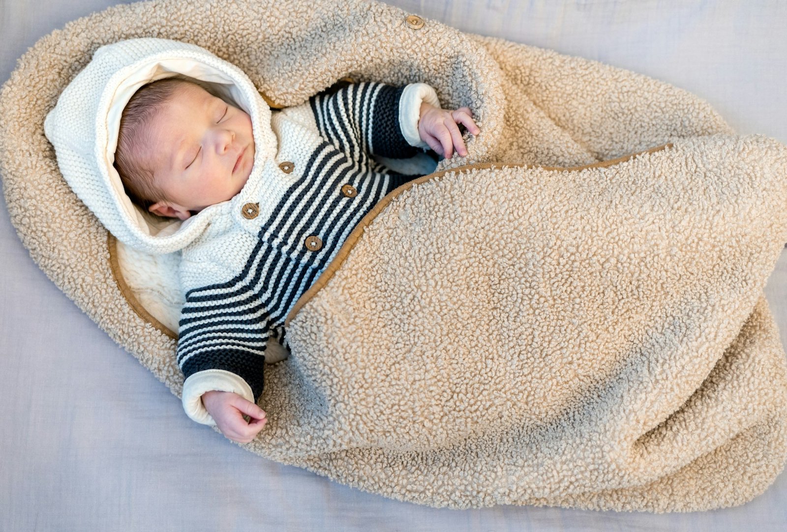 Cute newborn child sleeps wrapped baby blanket